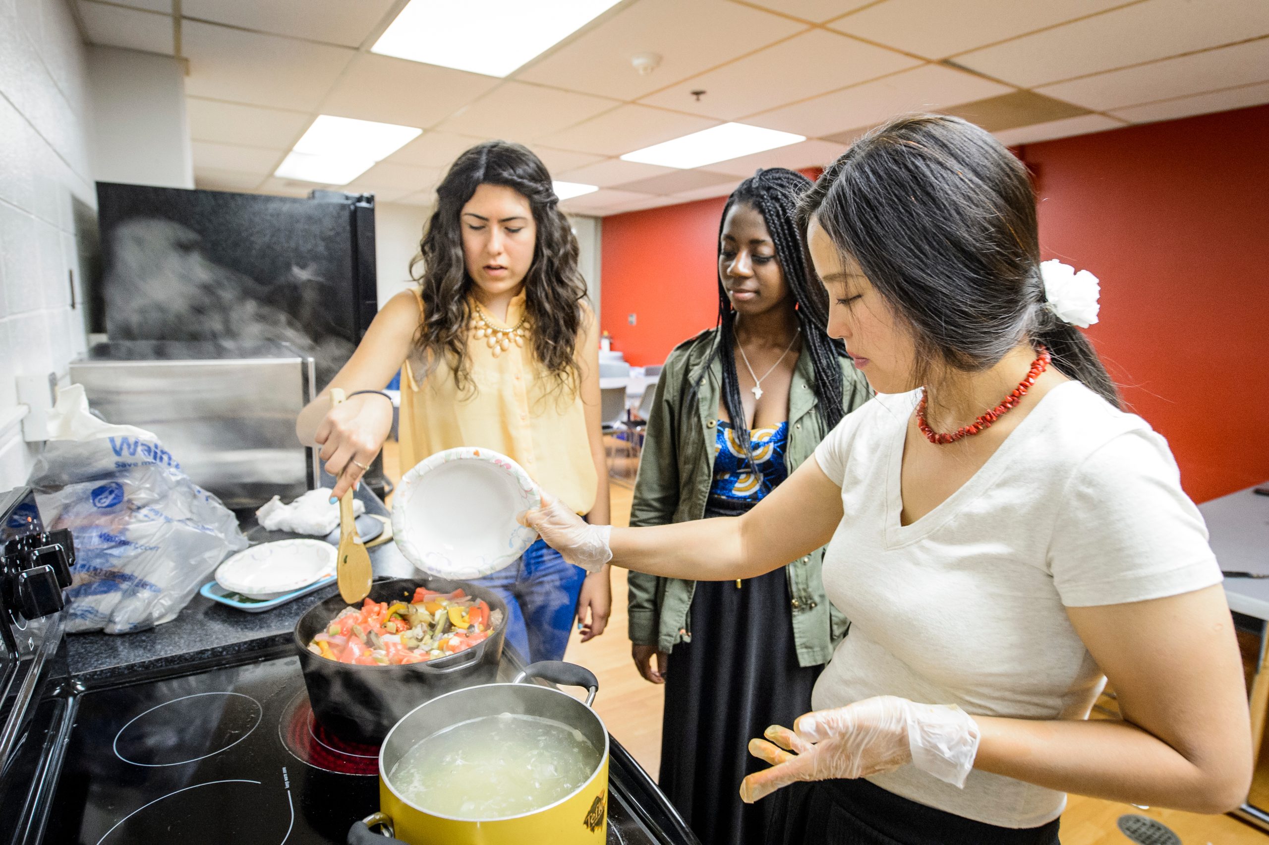 Three students cook together in Russkii Dom's kitchen. 