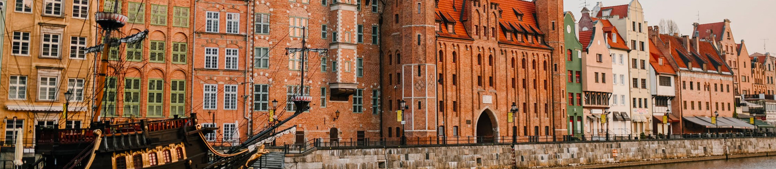 A photo of a historic waterfront of Gdańsk, Poland, along the Motława River.