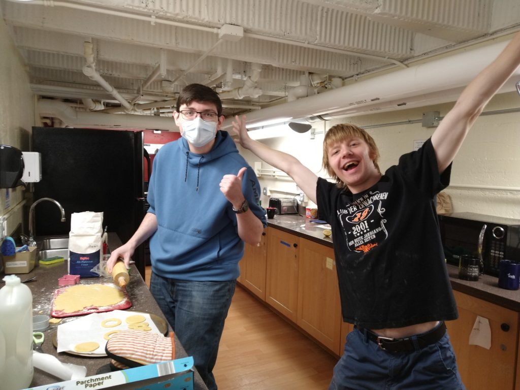A photo featuring residents of Stockwerk Deutsch baking cookies in a kitchen.