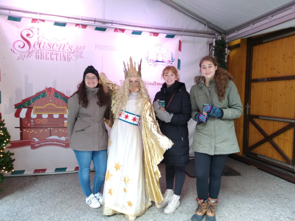 A photo featuring residents of Stockwerk Deutsch posing in front of a Christmas display.