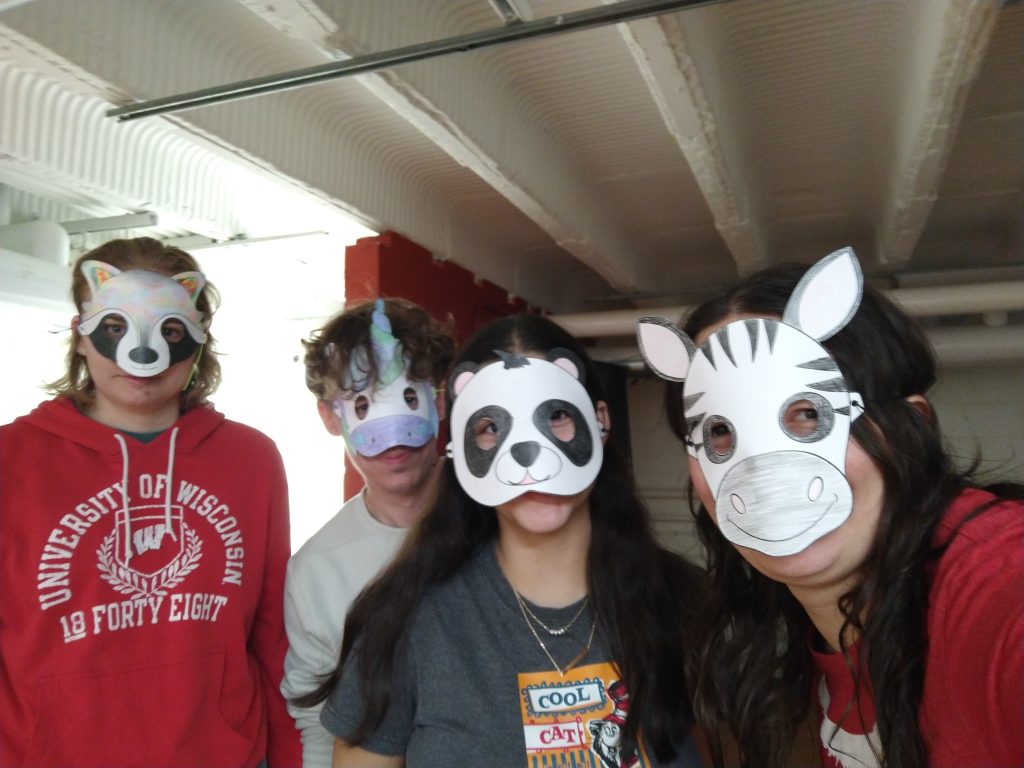 A photo featuring residents of Stockwerk Deutsch weearing paper masks, including a raccoon, a panda, and a zebra.