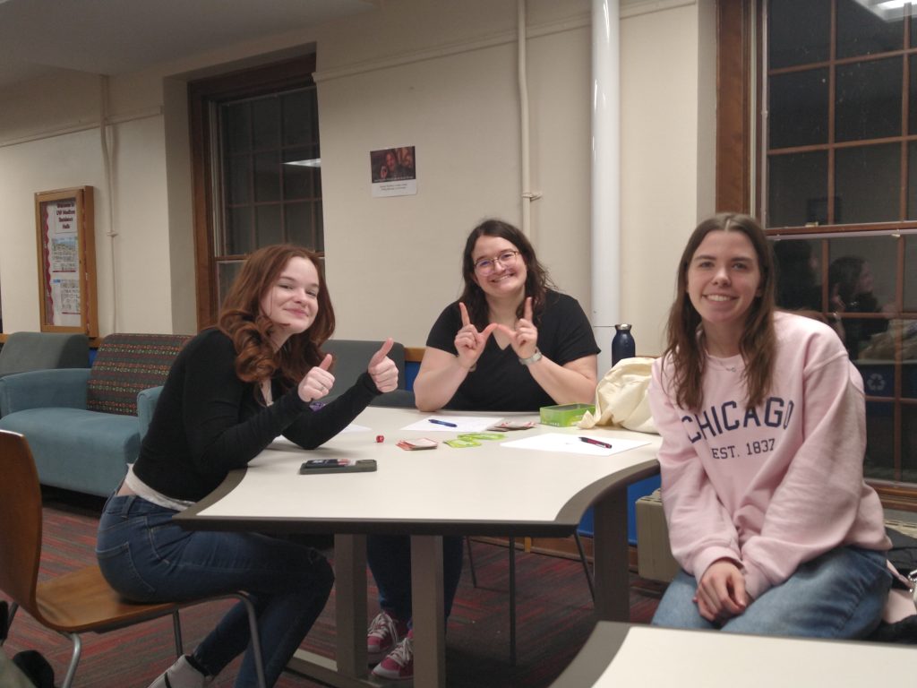A photo featuring residents of Stockwerk Deutsch sitting together at a table, smiling at the camera.