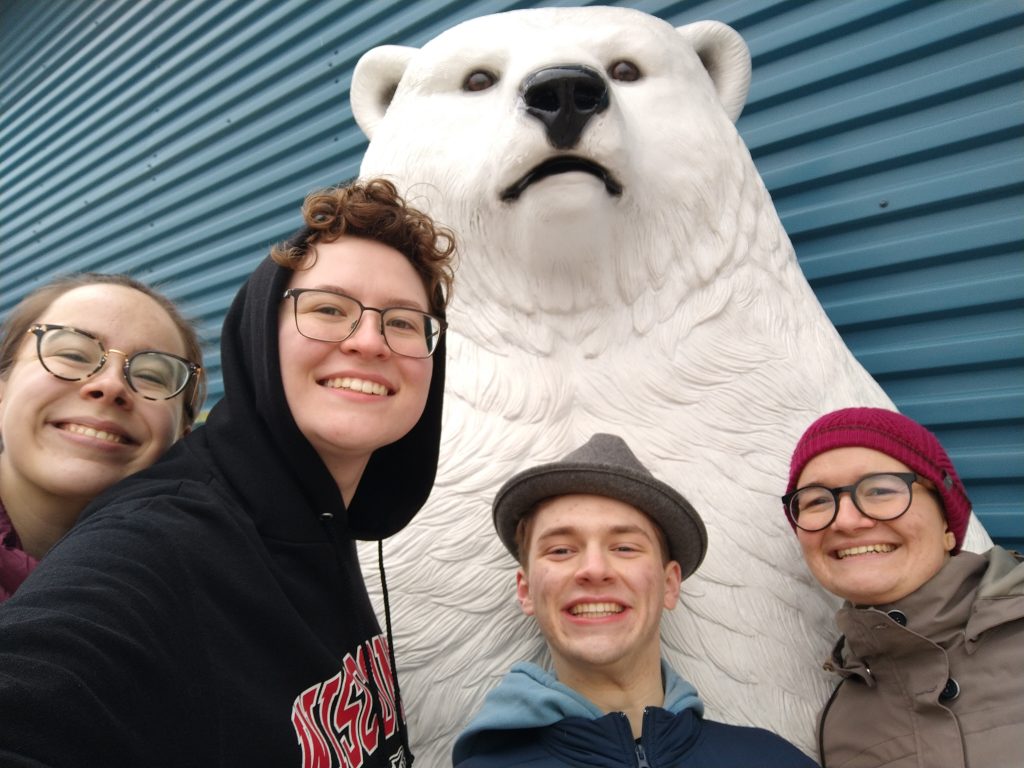 A photo featuring residents of Stockwerk Deutsch posing with a statue of a polar bear.