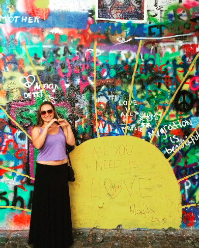 image of study abroad alumna Megan Veach standing in front of street art in Prague.