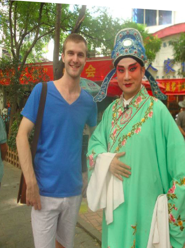image of study abroad alum Noah Mergendahl, in Wuhan, China, standing with a traditional "Chu" opera singer.