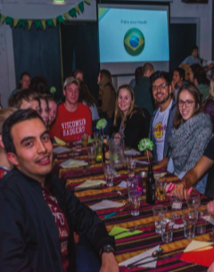 image of study abroad alum Collin Wimmler (in red) participating in an International Kitchen event, which allowed students from different countries to showcase their food.