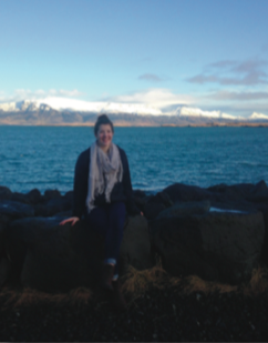 image of study abroad alumna Josie Sajbel in front of Mount Esja and the mountain range across the ocean from Reykjavik.
