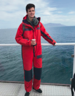 image of study abroad alum Riley Ford whale-watching in Iceland.
