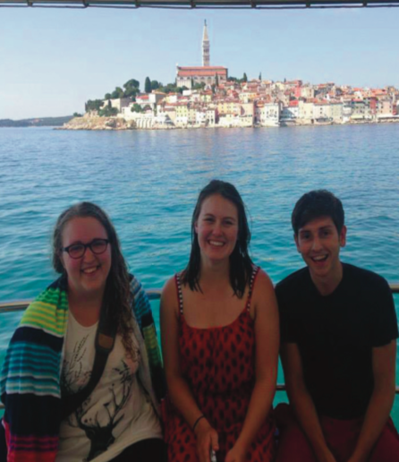 image of study abroad alumna Makayla Dehne (center) with two other UW students with the city of Rovinj in the background.